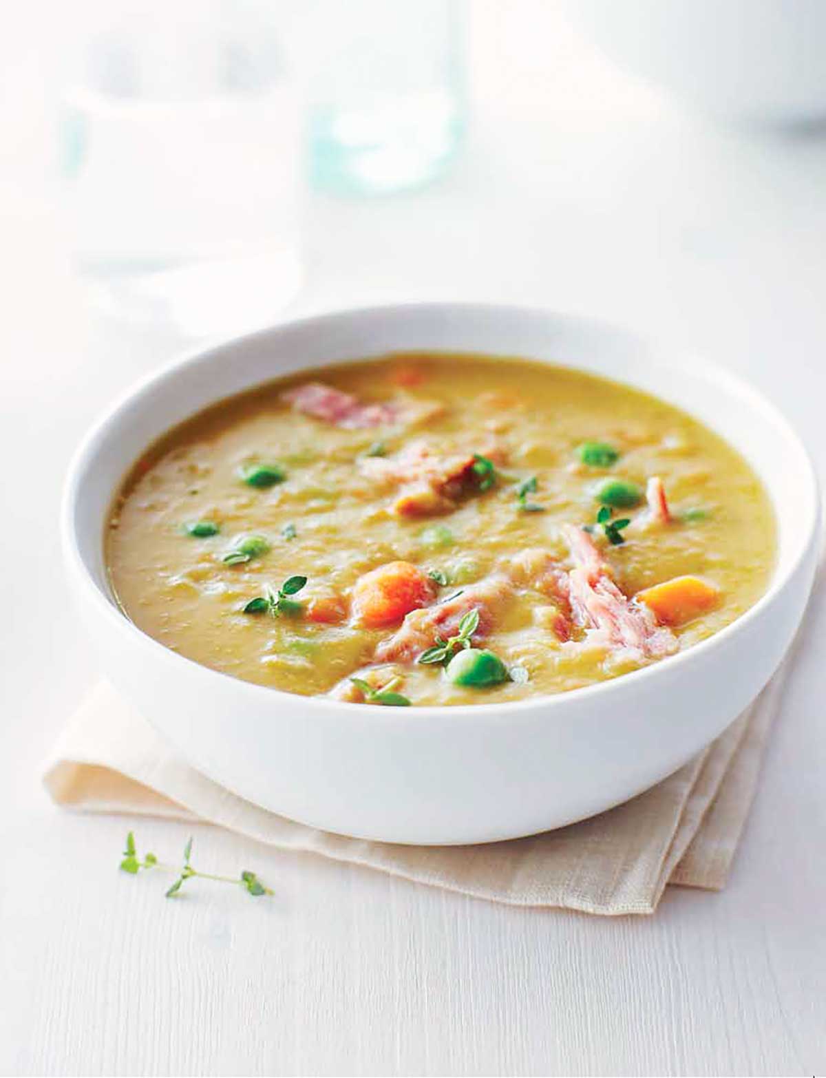 A white bowl filled with slow cooker split pea soup on a napkin.