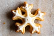 A snowflake cookies frosted with royal icing on a granite background.