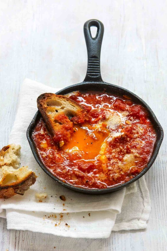 Spicy eggs in hell in a small cast-iron skillet, and half a piece of toasted bread.