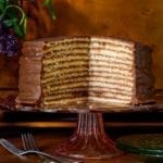 Trisha Yearwood's chocolate torte on a cake stand with a section cut from it to display 12 layers.