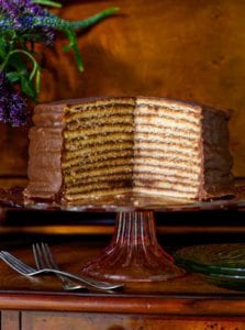 Trisha Yearwood's chocolate torte on a cake stand with a section cut from it to display 12 layers.