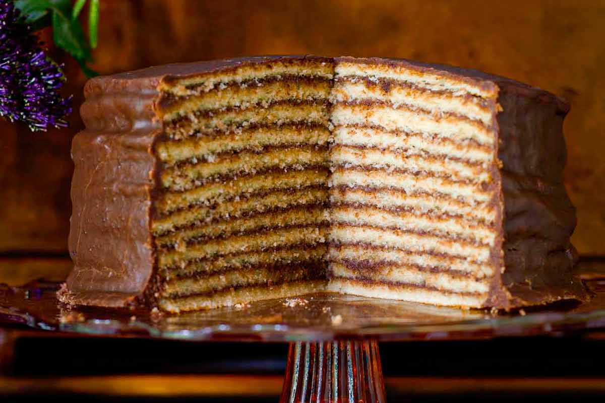Trisha Yearwood's chocolate torte on a cake stand with a section cut from it to display 12 layers.