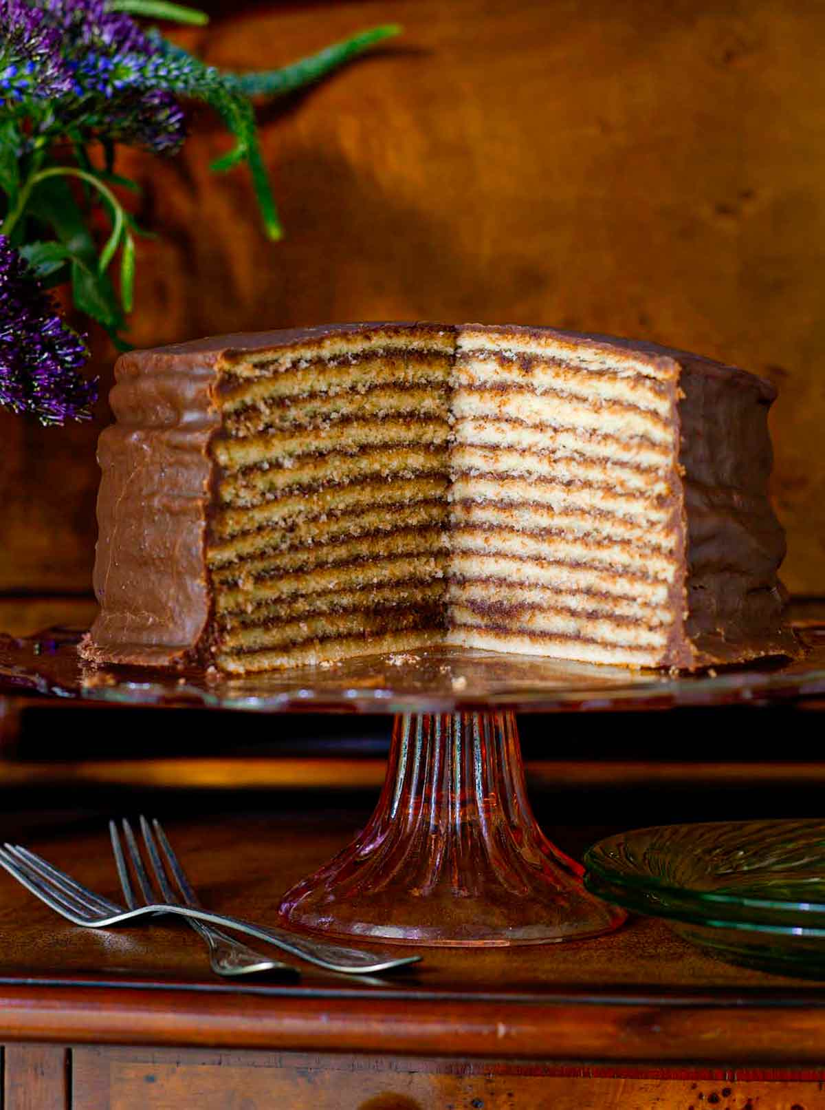 Trisha Yearwood's chocolate torte on a cake stand with a section cut from it to display 12 layers.