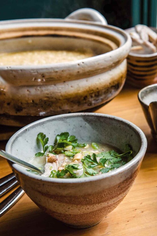 A bowl filled with Vietnamese chicken soup with a spoon resting in it.