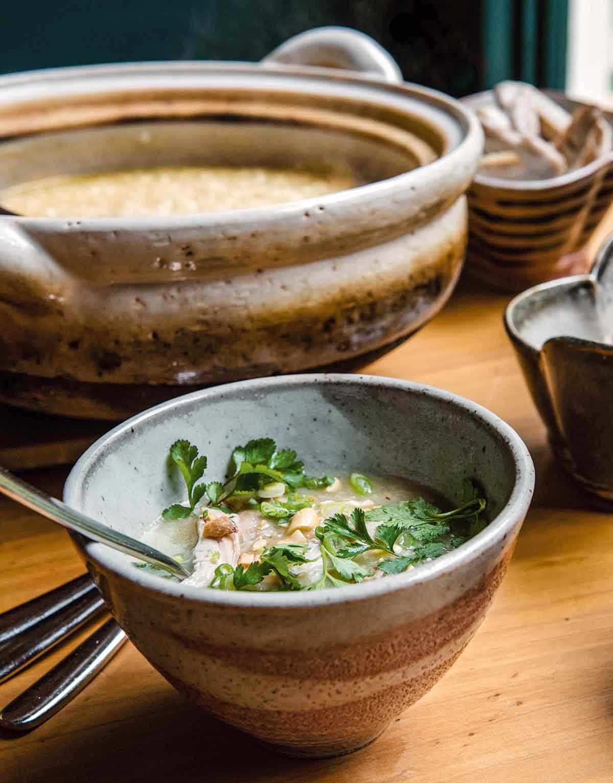 A bowl filled with Vietnamese chicken soup with a spoon resting in it