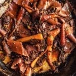 Braised beef with red wine pasta and carrots in a skillet.