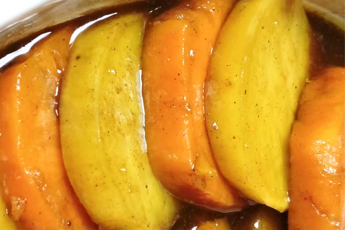 Sliced yellow and white candied sweet potatoes in an oval baking dish.