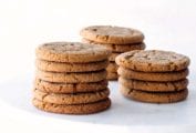 Three stacks of chewy molasses cookies on a white marble cake stand.