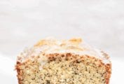 A cut citrus poppy seed cake with a white glaze.