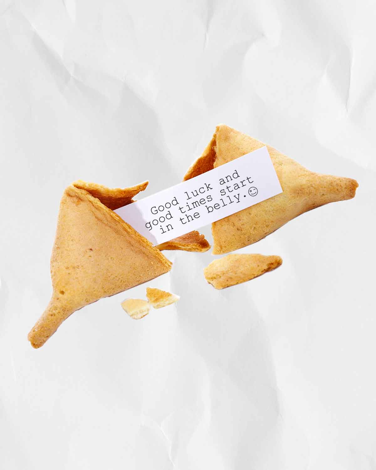 A broken fortune cookie with a fortune inside, representing the lucky foods you need to eat on New Years—and the unlucky ones you want to avoid.