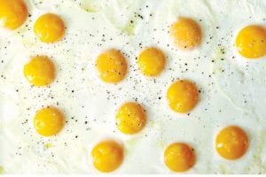 Sunny side up sheet pan eggs on a baking sheet.