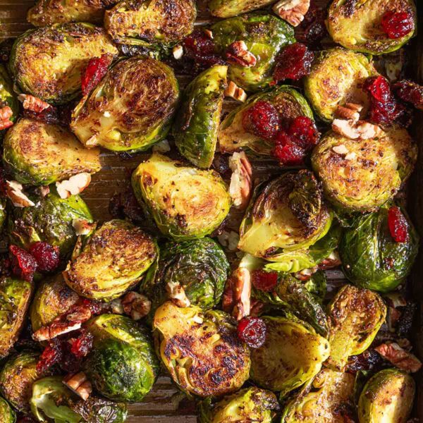 A tray of roasted Brussels sprouts with cranberries and pecans.