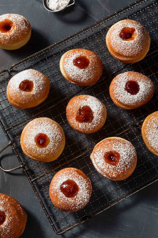 coolingh rack with 12 sufganiyah--Jewish jelly doughnuts on it.