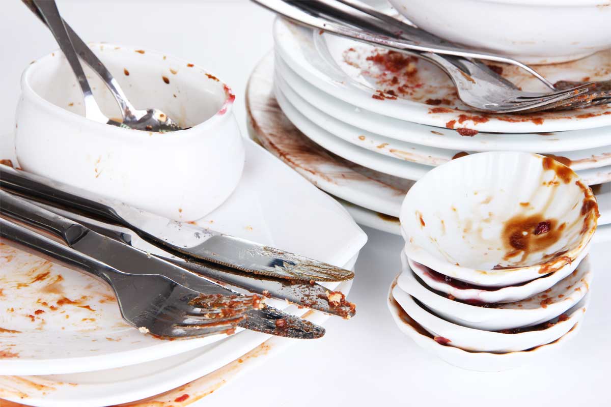 A stack of dirty dishes, illustrating 10 life lessons learned in the kitchen.