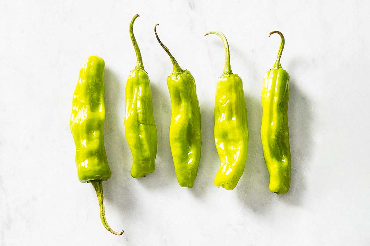 Five banana peppers as illustration for 'what's the difference among chile peppers?'