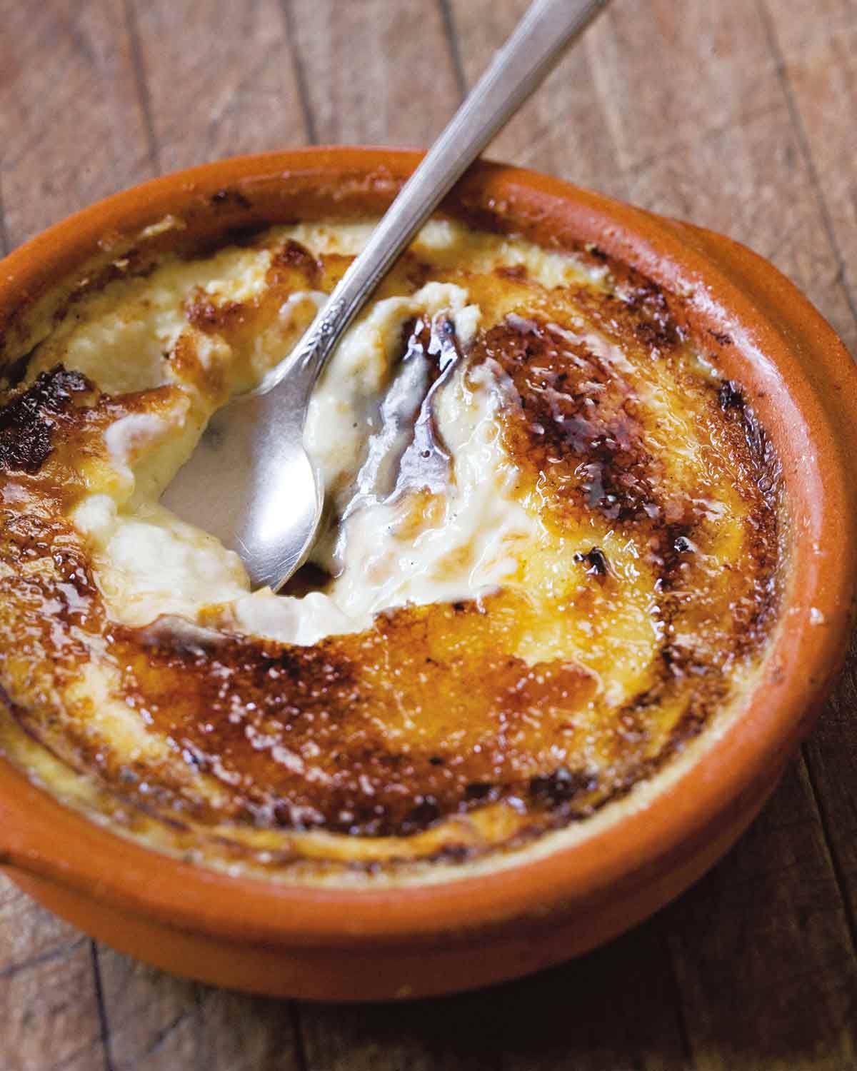 A spoon resting inside a bowl of Catalan custard.