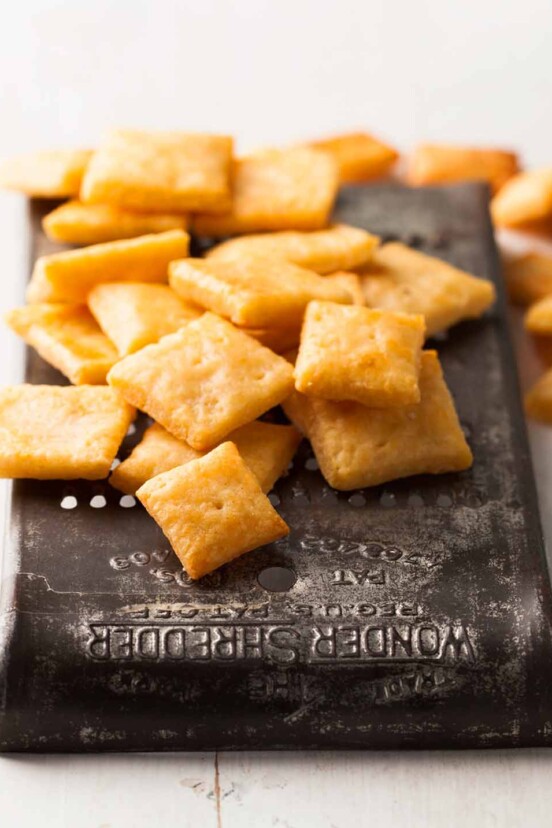 A pile of cheese crackers on an old metal grater.