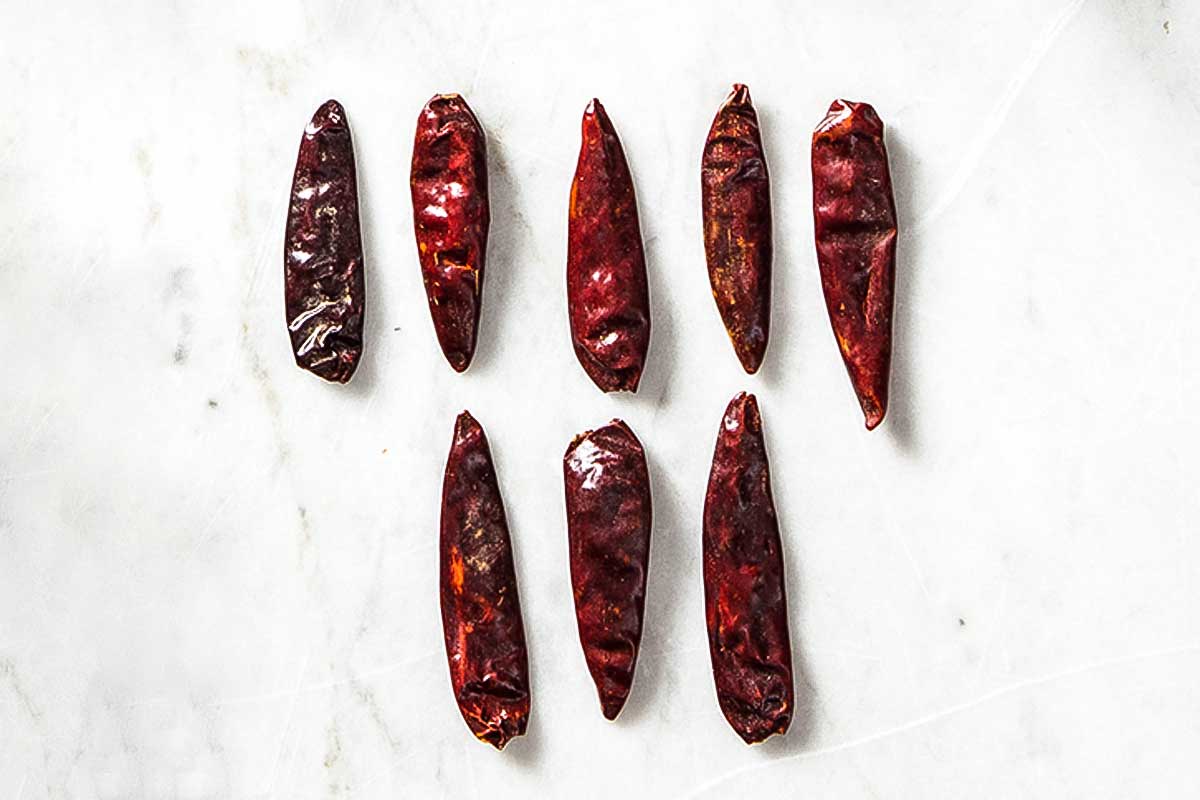Eight dried calabria peperoncini chile peppers to illustrate the difference among dried chile peppers.