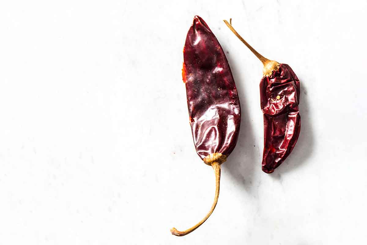 Two dried New Mexican chile peppers to illustrate the difference among dried chile peppers.