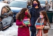 Two girls and a parent delivering Girl Scout cookies