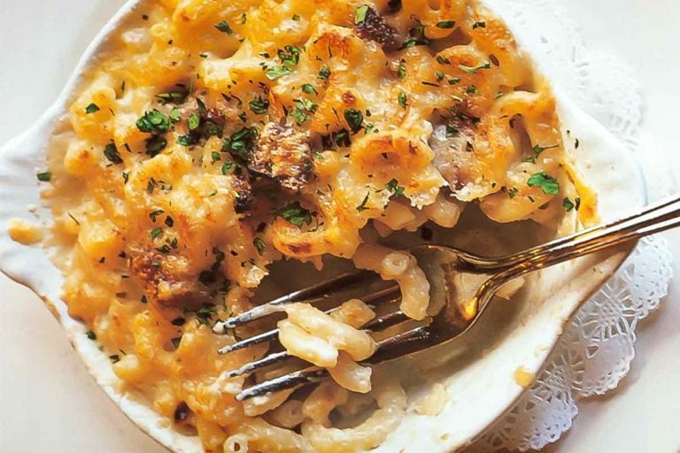 A white dish of macaroni gratin with a fork resting inside.