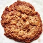 A single oat and pecan brittle cookie on a white background.