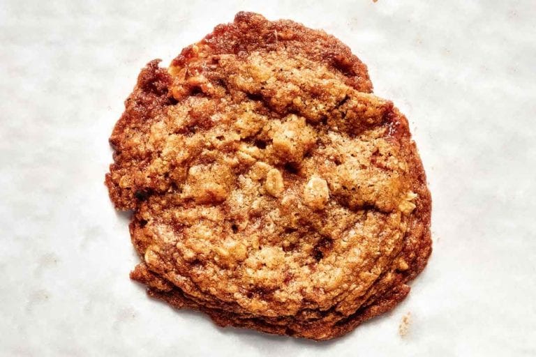 A single oat and pecan brittle cookie on a white background.