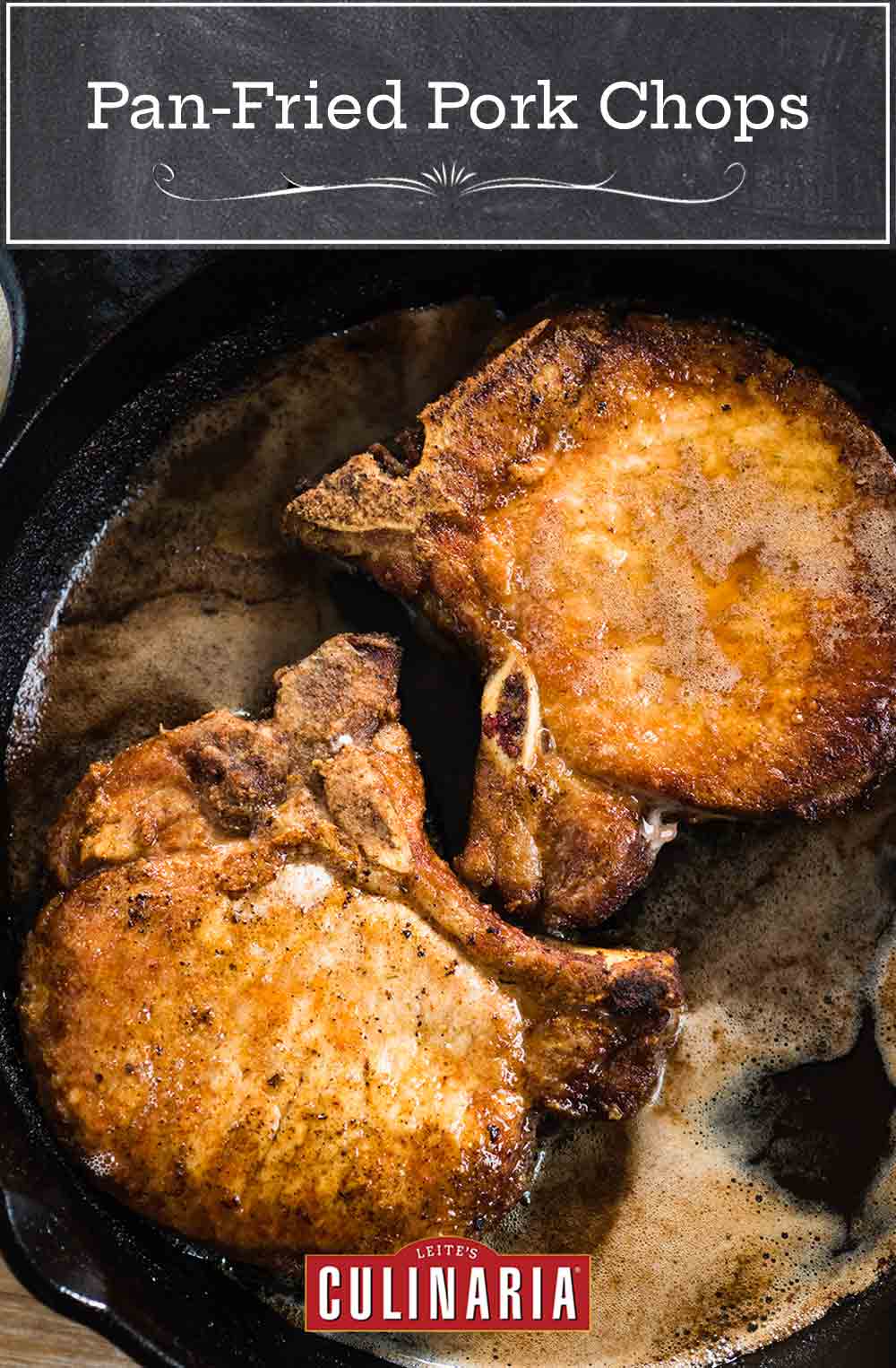 Two golden pan-fried pork chops in a cast-iron skillet.