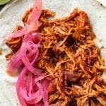 Pulled pork tacos with habanero salas and pickled onions on flour tortillas.