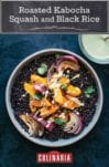 A white bowl filled with roasted kabocha squash, black rice, and sesame dressing drizzled over and in a glass on the side.