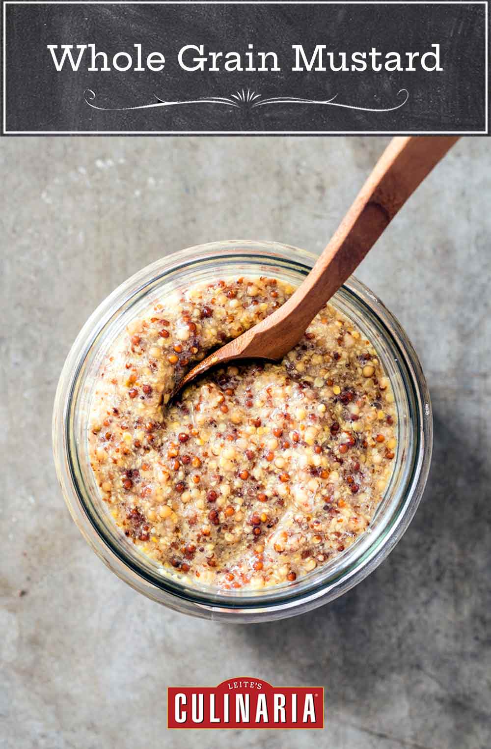 A jar of whole grain mustard with a wooden spoon in it.