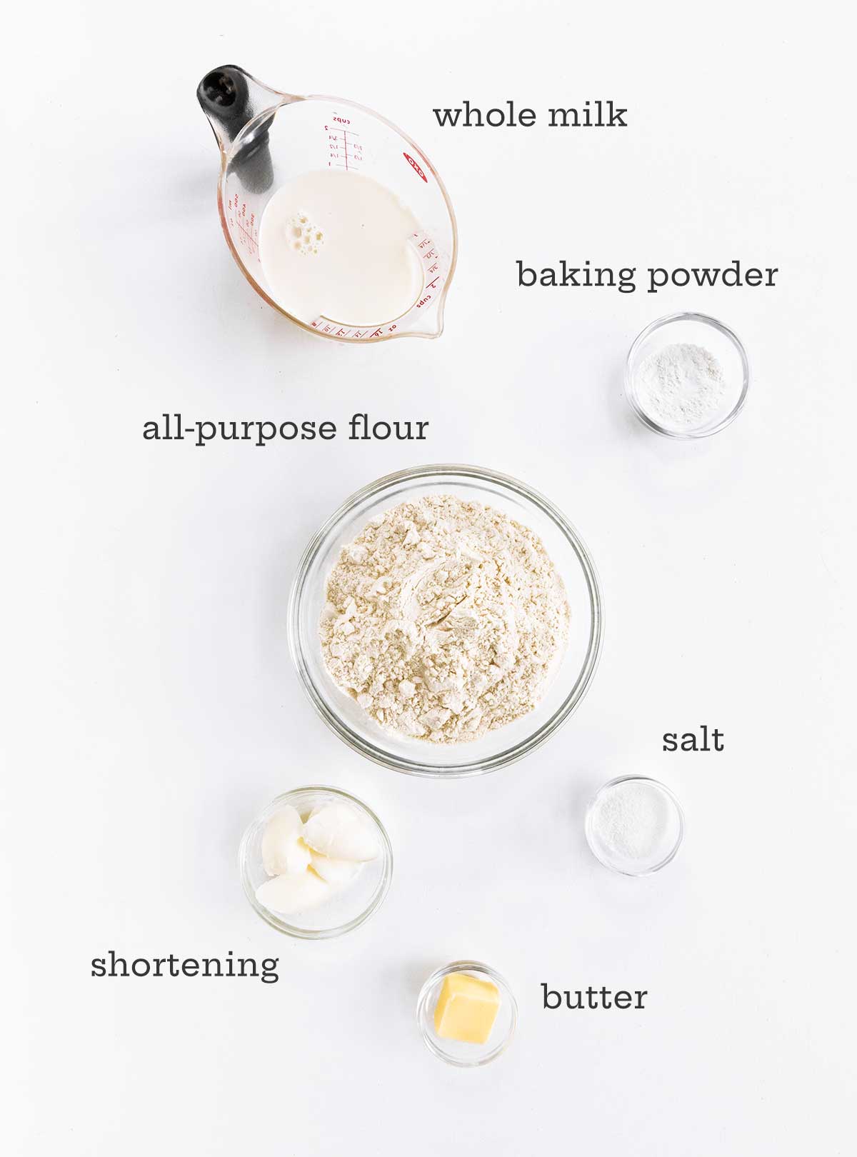 Ingredients for baking powder biscuits -- buttermilk, baking powder, flour, salt, shortening, and butter.