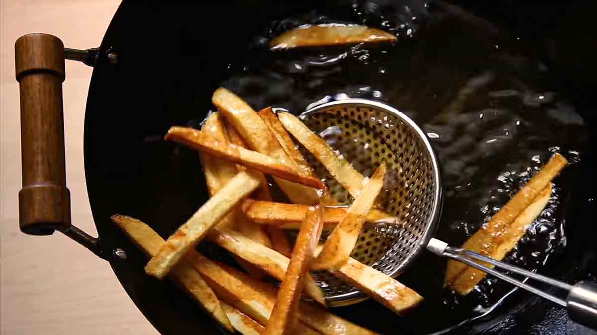 Fries being cooked in a wok for the podcast Talking With my Mouth Full, Ep. 39: Everything Wok with Grace Young.