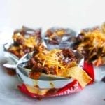 Several Frito pies made in open bags of Fritos.