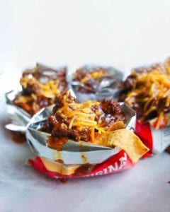 Several Frito pies made in open bags of Fritos.