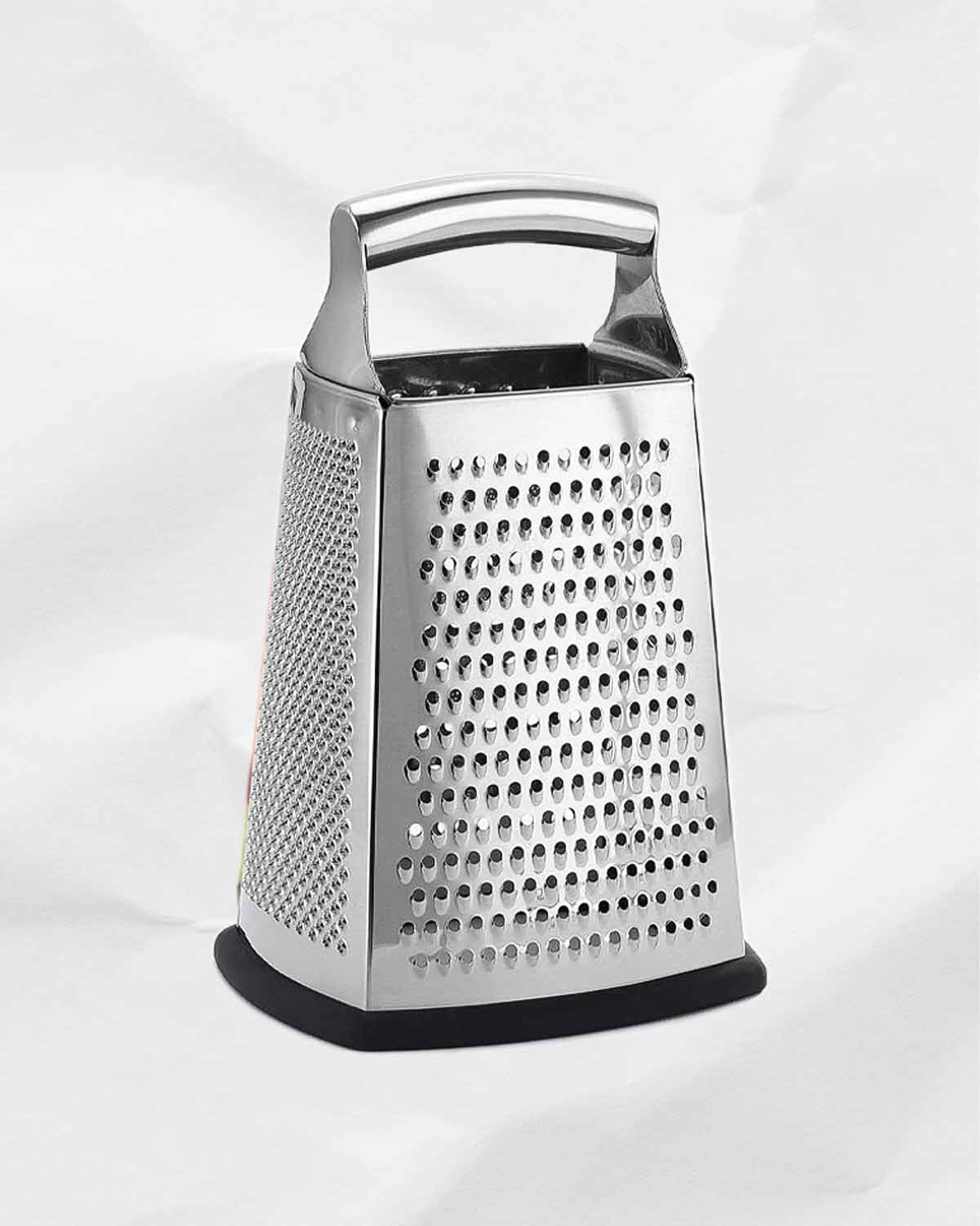 A stainless steel box grater for the writing 'how to use all four sides of your box grater'.