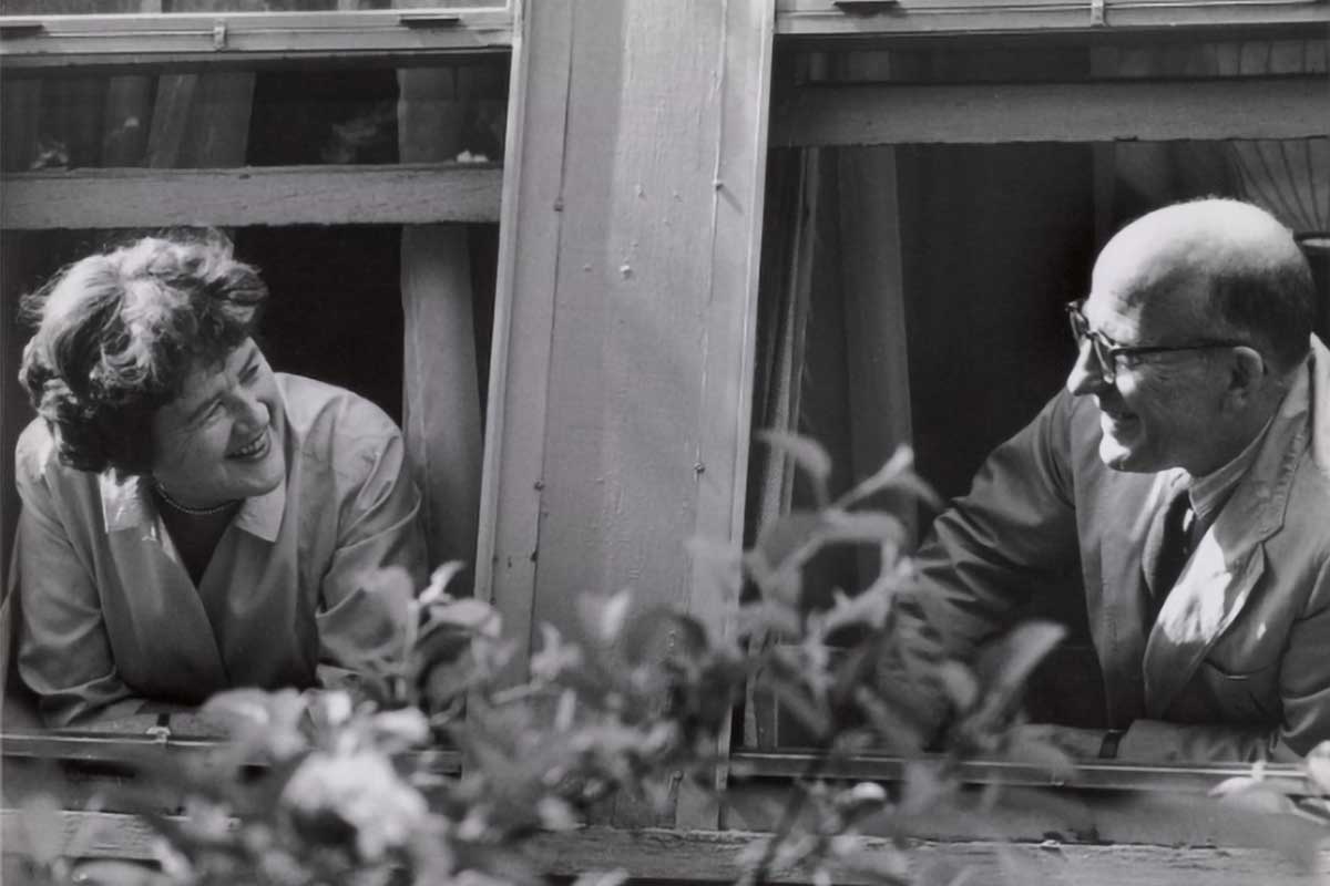 Julia Child and Paul Child looking at each other out a window.