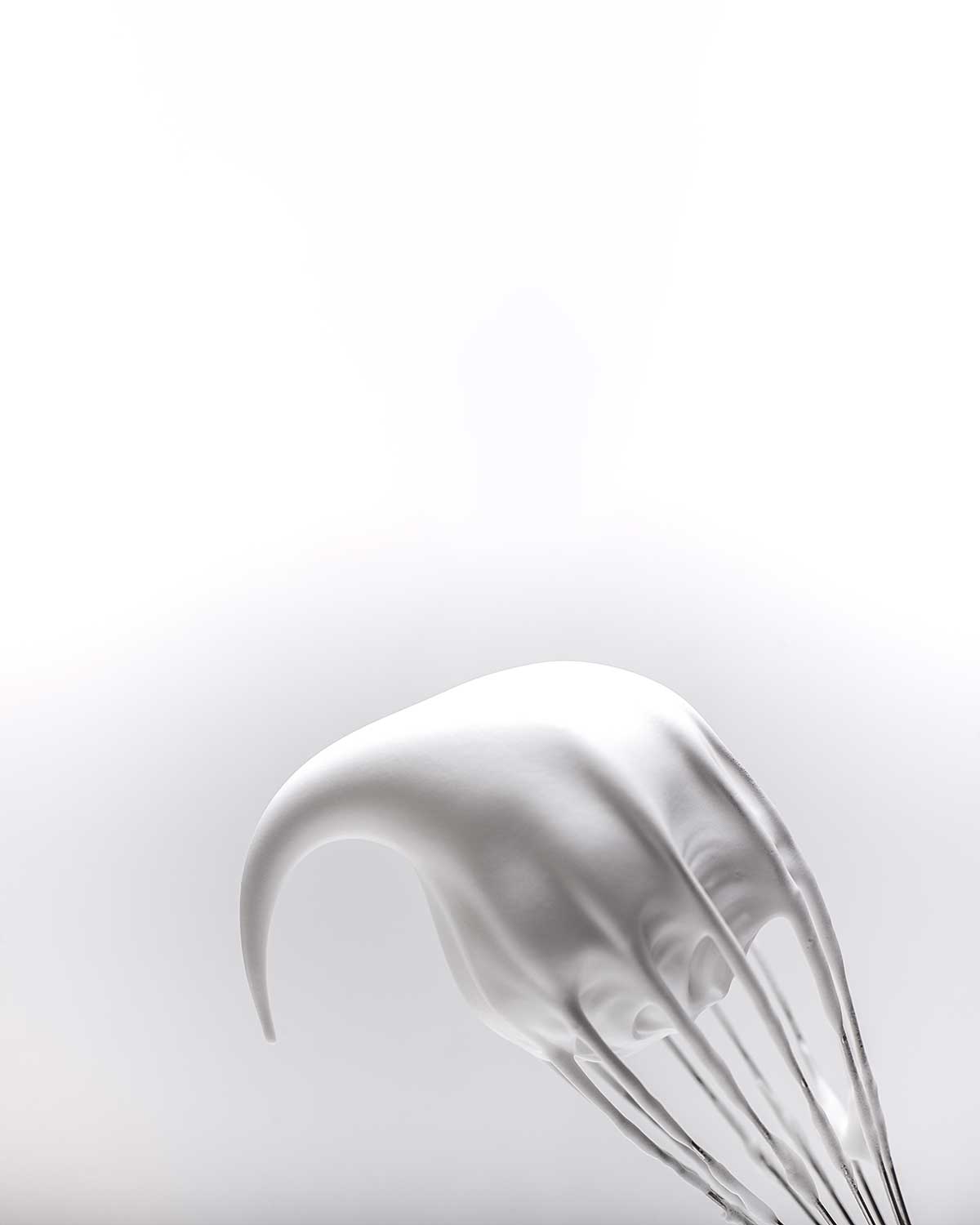 Meringue on a whisk, as illustration of the difference between French, Italian, and Swiss meringues.