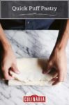 A person folding quick puff pastry on a marble counter.