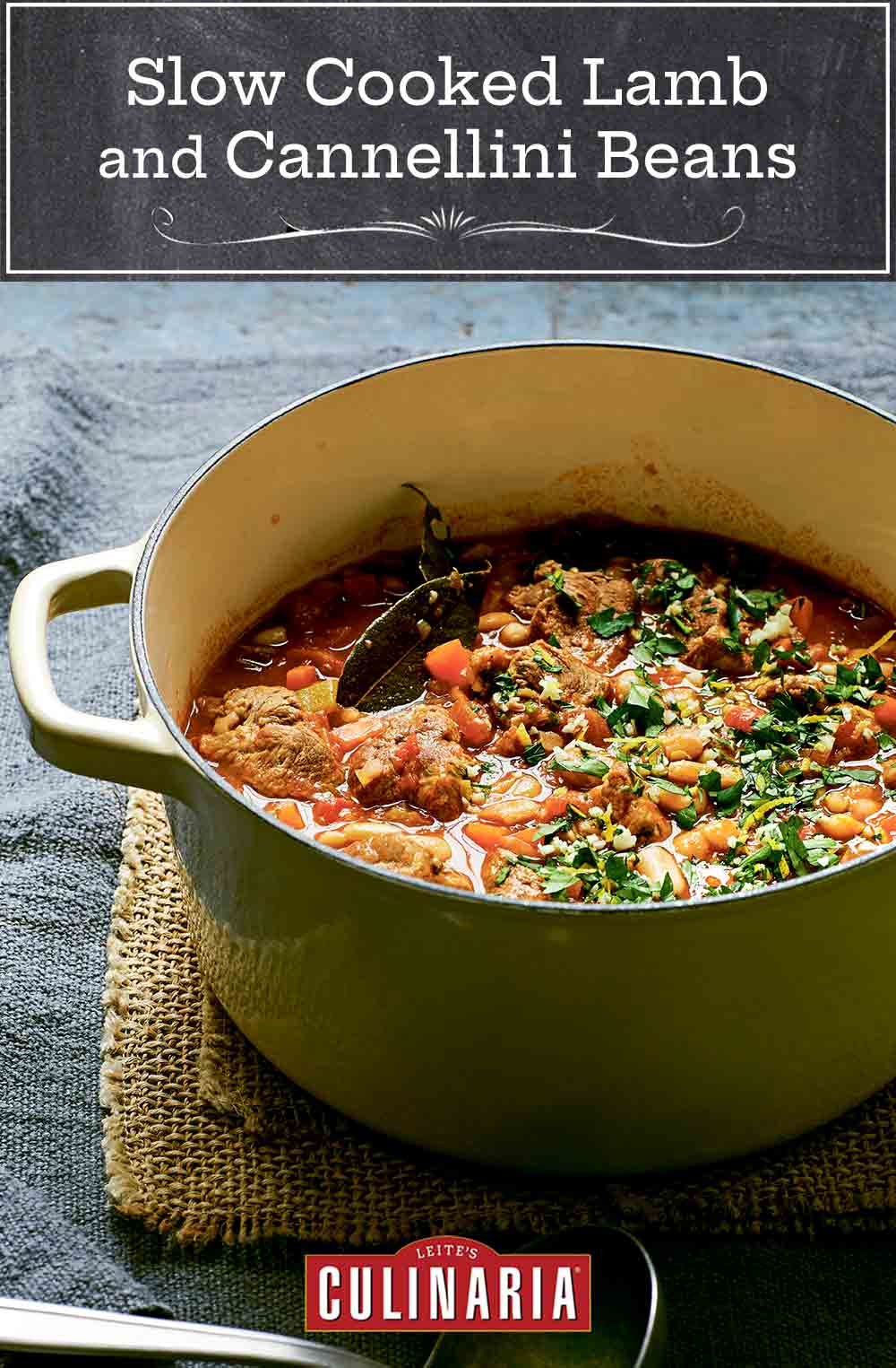 A round green Dutch oven filled with slow cooked lamb and cannellini beans on a brown burlap cloth.