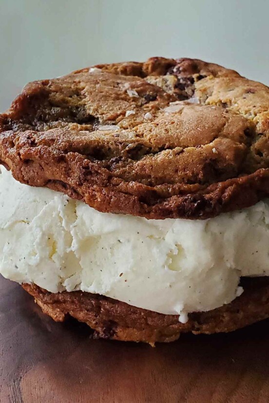 A cookie ice cream sandwich made with sourdough chocolate chip cookies and vanilla ice cream.