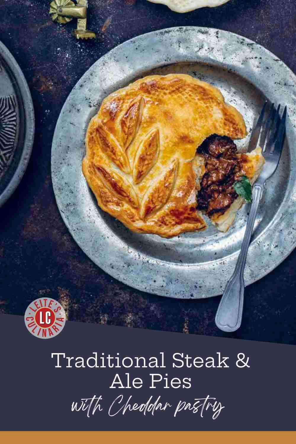 Golden individual beef pies on a rustic metal plate with a fork, showing a rich meat filling.