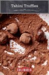 Five tahini truffles lying in a bed of cocoa powder.