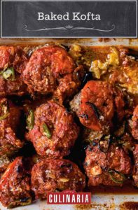 A ceramic baking dish filled with baked kofta -- meatballs on top of eggplant slices, all covered in tomato sauce.