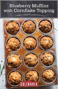 A 12 cup muffin tin filled with blueberry muffins with cornflake topping.