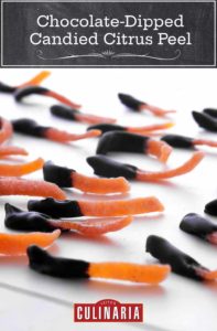 Strips of chocolate dipped candied orange peel on a white surface.