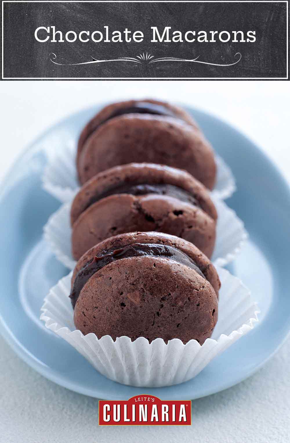 Three chocolate macarons in paper wrappers in a blue dish.