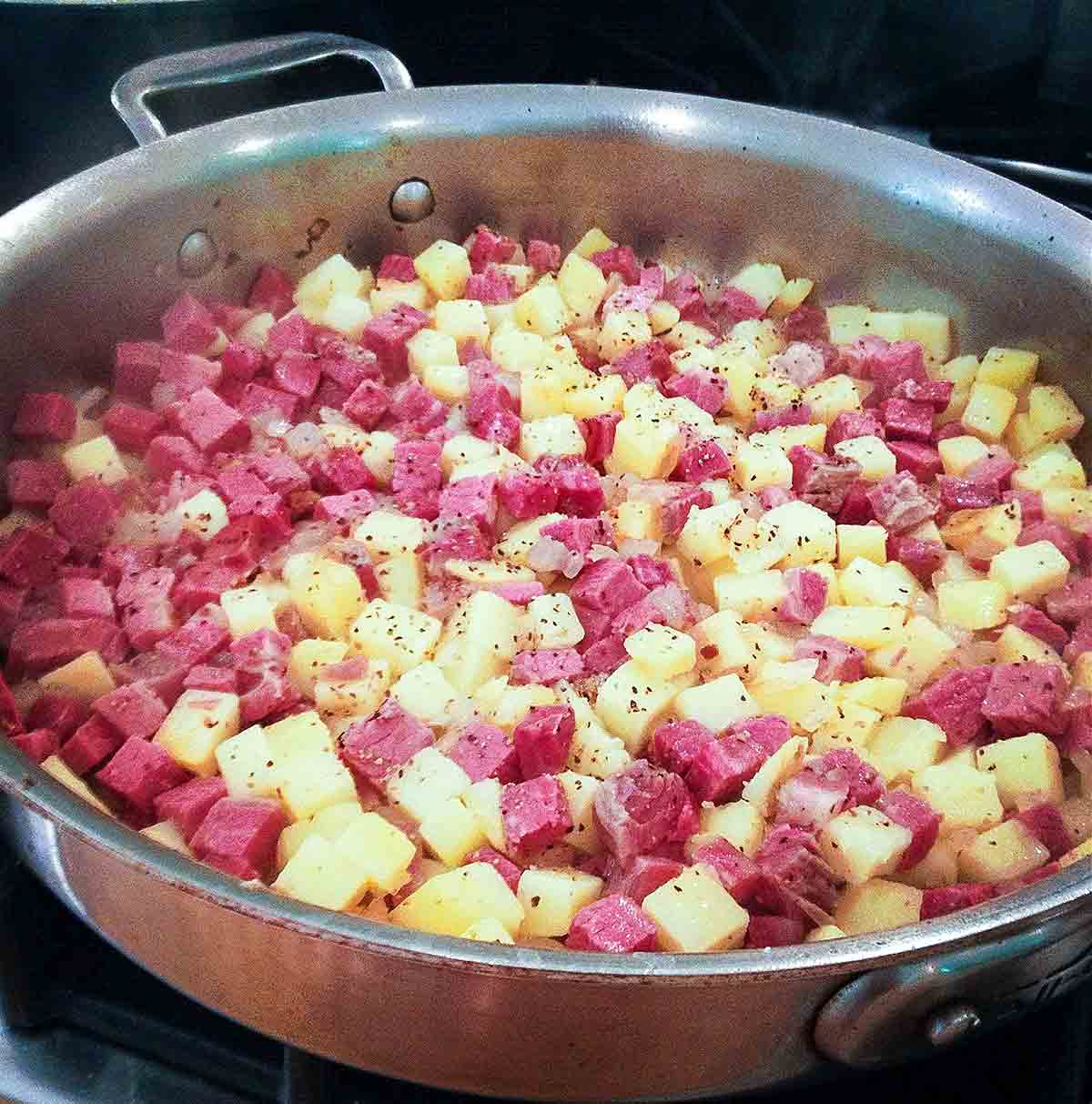 A skillet with corned beef hash that needs to be sauted