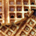 A close view of cornmeal waffles overlapping each other.