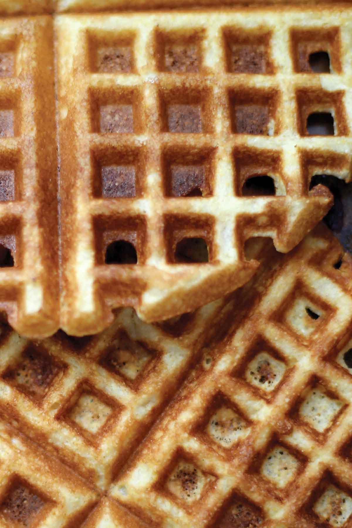 A close view of cornmeal waffles overlapping each other.